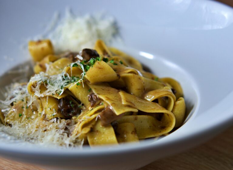 Italian Oyster Mushroom Garlic Butter Pasta: Close-up of pappardelle pasta topped with parmesan cheese and mushrooms, perfect for Italian cuisine lovers.