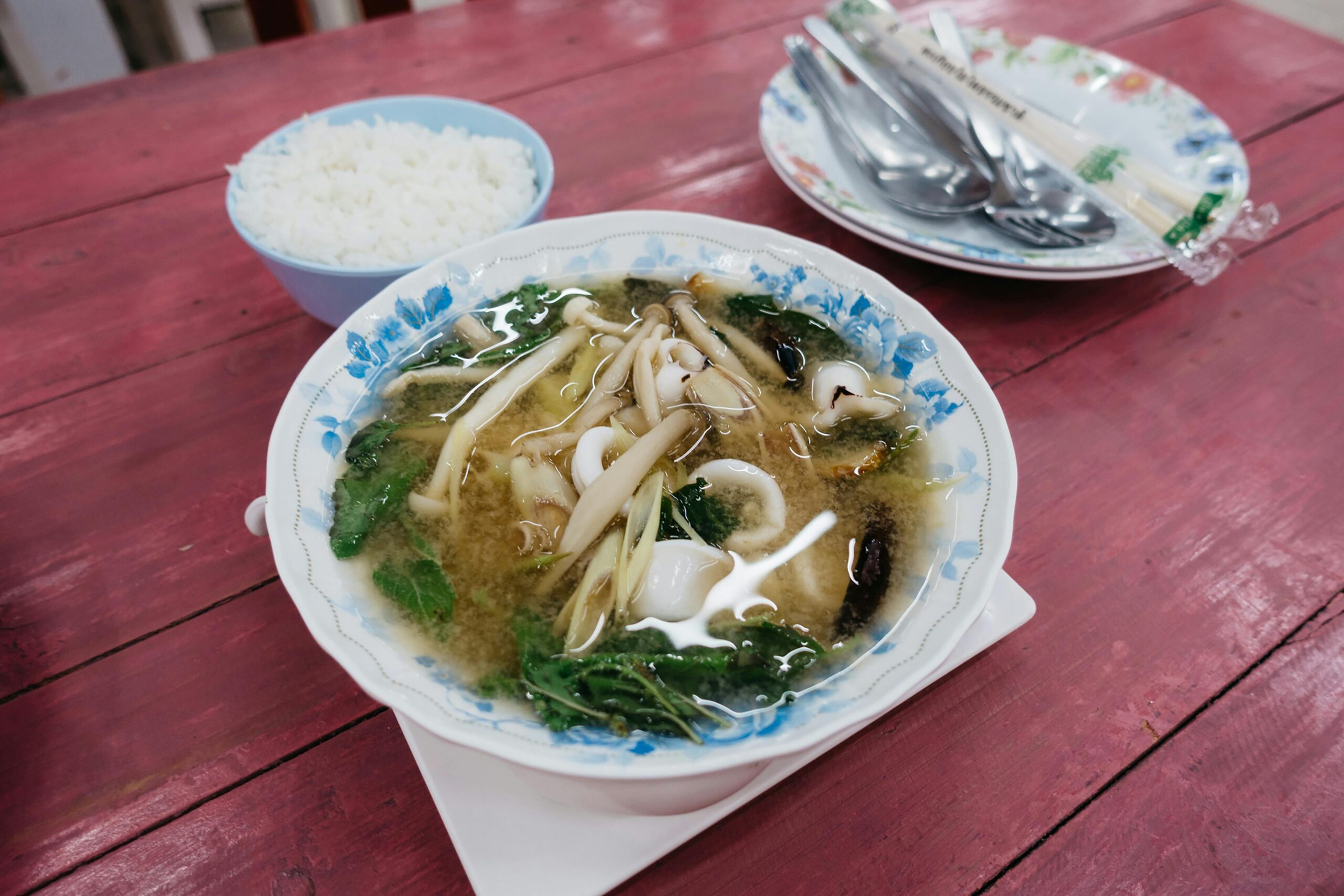 Shiitake Miso Ramen - Delicious seafood miso soup with fresh vegetables and a side of steamed rice served on a rustic table.