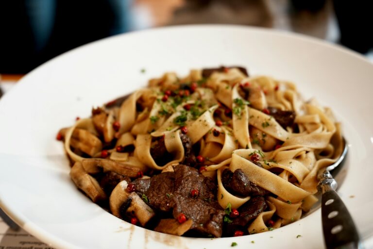A mouthwatering dish of beef tagliatelle garnished with fresh herbs and spices.